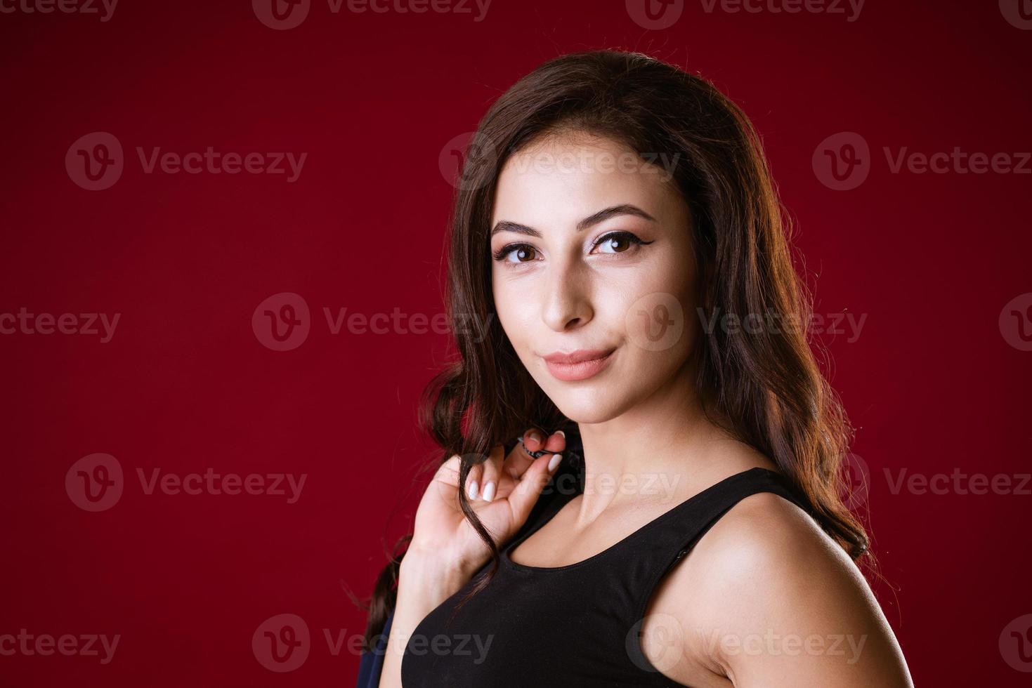 portrait of a brunette girl on a red background photo