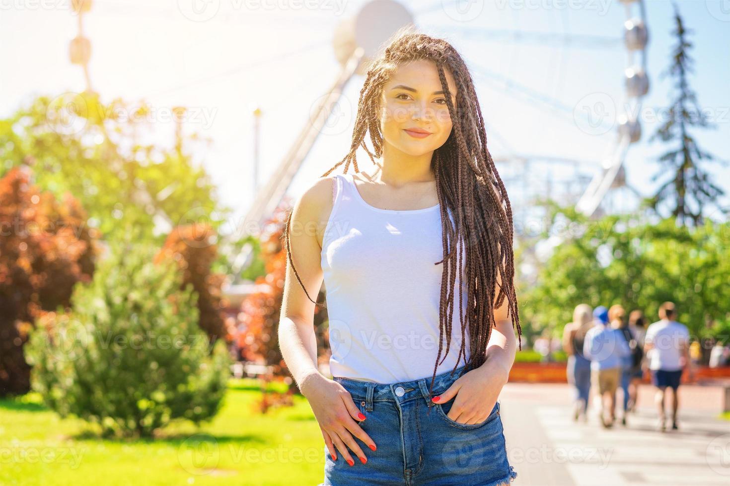 Happy smile girl stands in an amusement Park on a Sunny day. Trendy portrait . photo