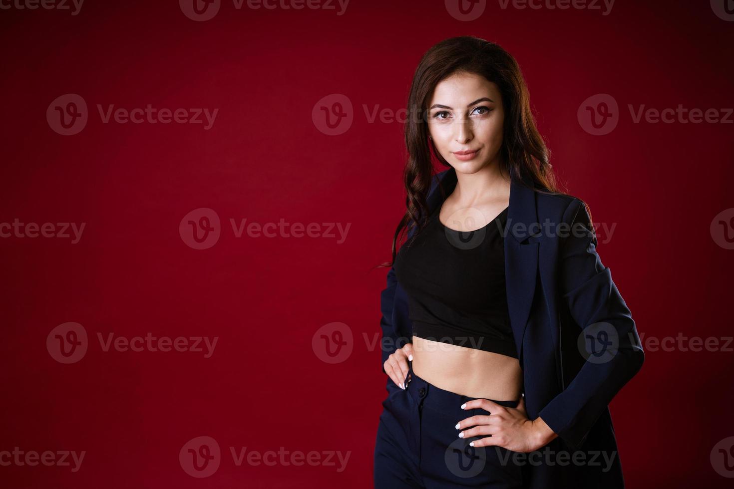 Young beautiful european stylish brunette woman in black blouse and dark blue photo