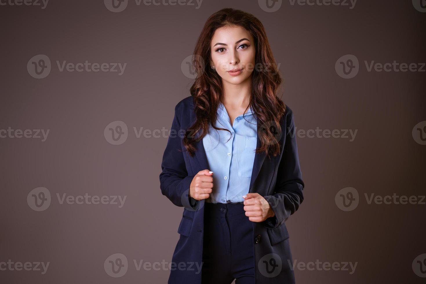 The woman holds onto her jacket, creating solidity against a dark background. photo