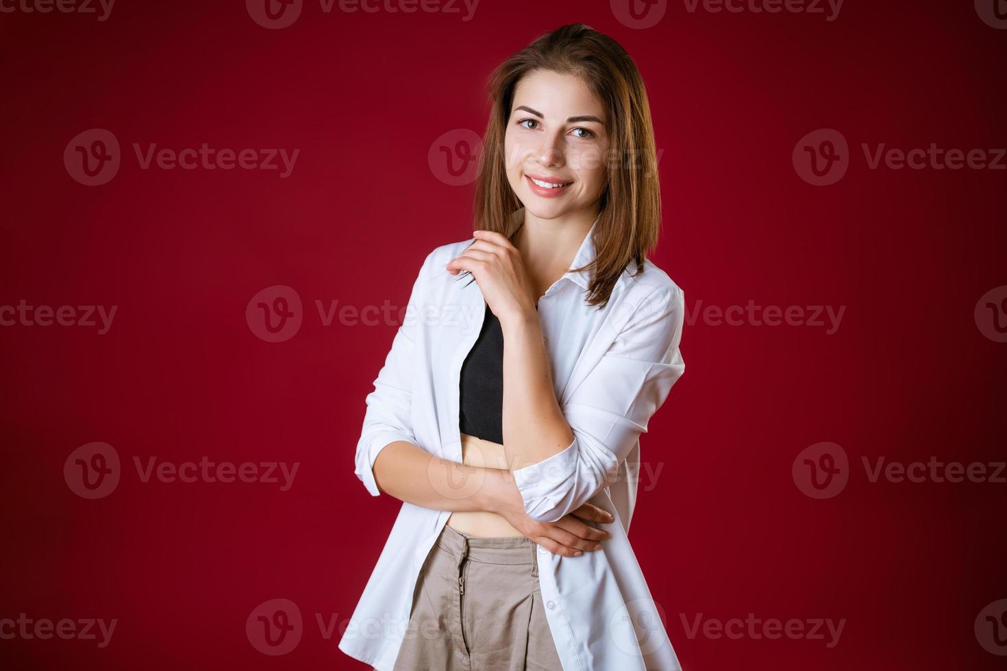 retrato de una hermosa joven posando sobre un fondo rojo foto