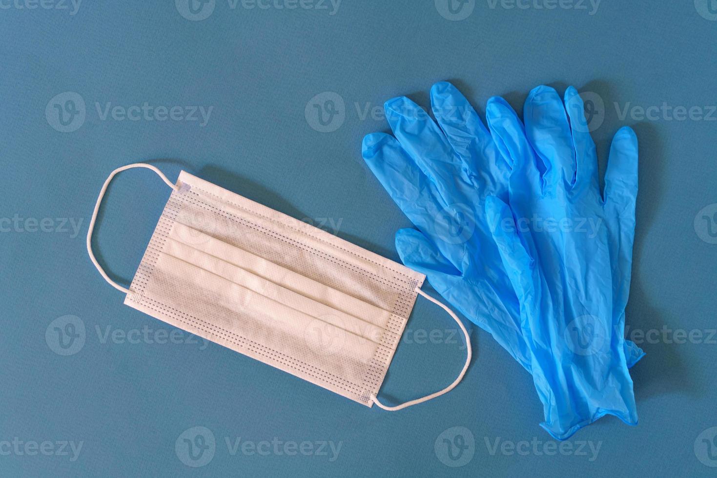 Medical mask and gloves on a blue background photo