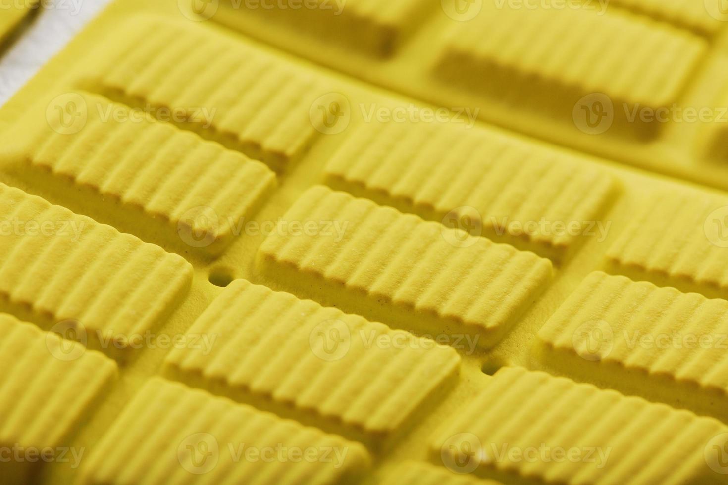 Close-up of the tread of a yellow sneaker, the textured pattern of the sole. photo