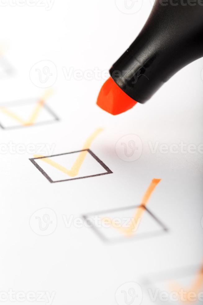 Orange marker with markers on the checklist sheet. photo