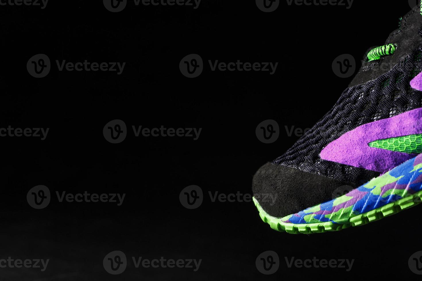 Multi-colored sports sneakers on a black background. photo