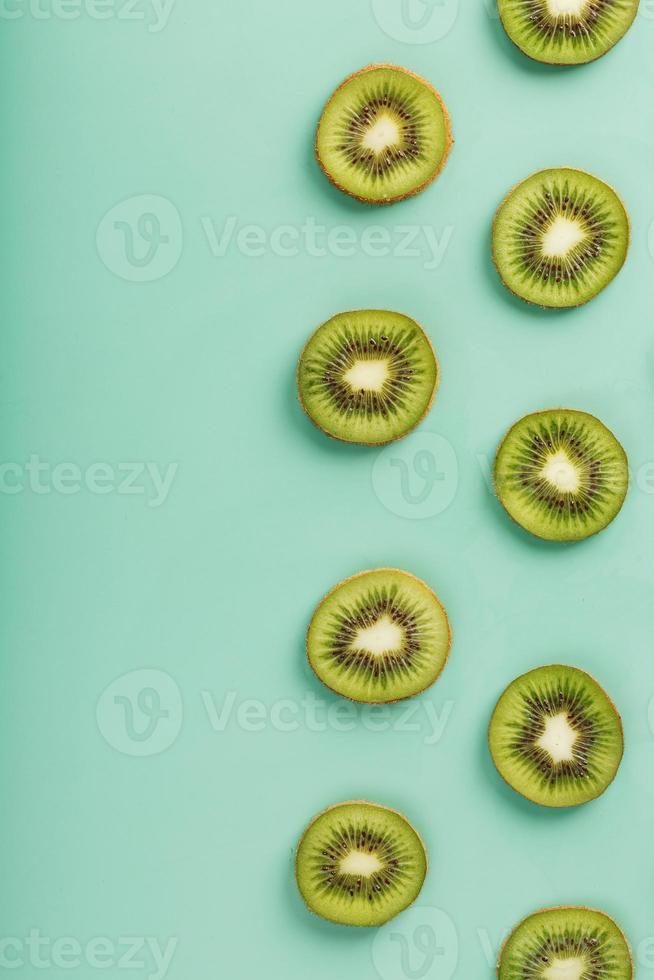 los patrones de las rodajas de kiwi sobre fondo verde como un fondo continuo. foto