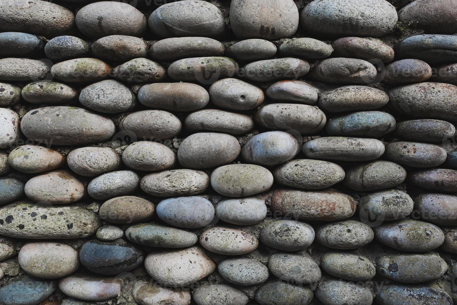 la textura de la pared de piedra, mampostería de piedras ovaladas naturales. foto