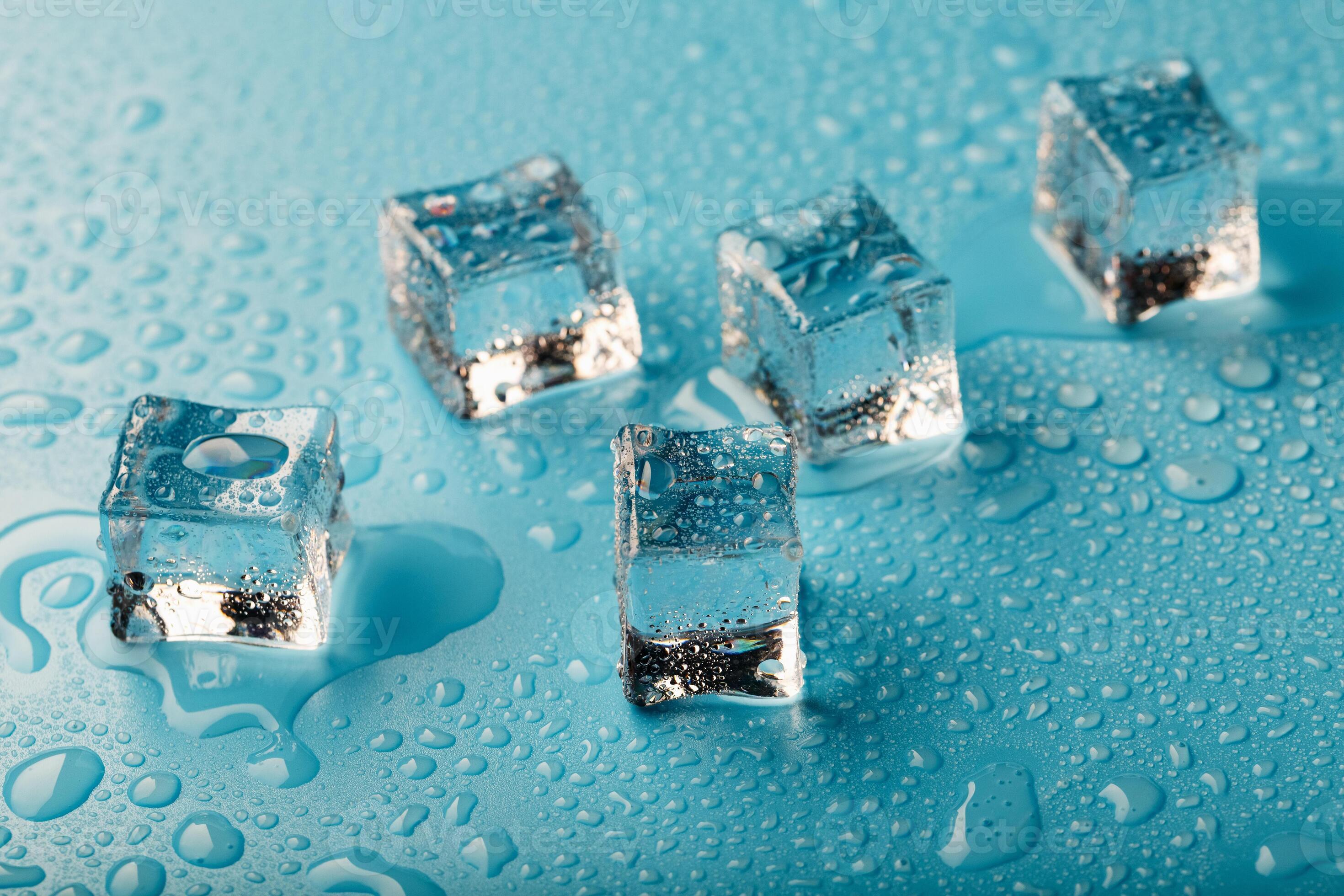 Ice cubes are scattered with water drops scattered on a blue background