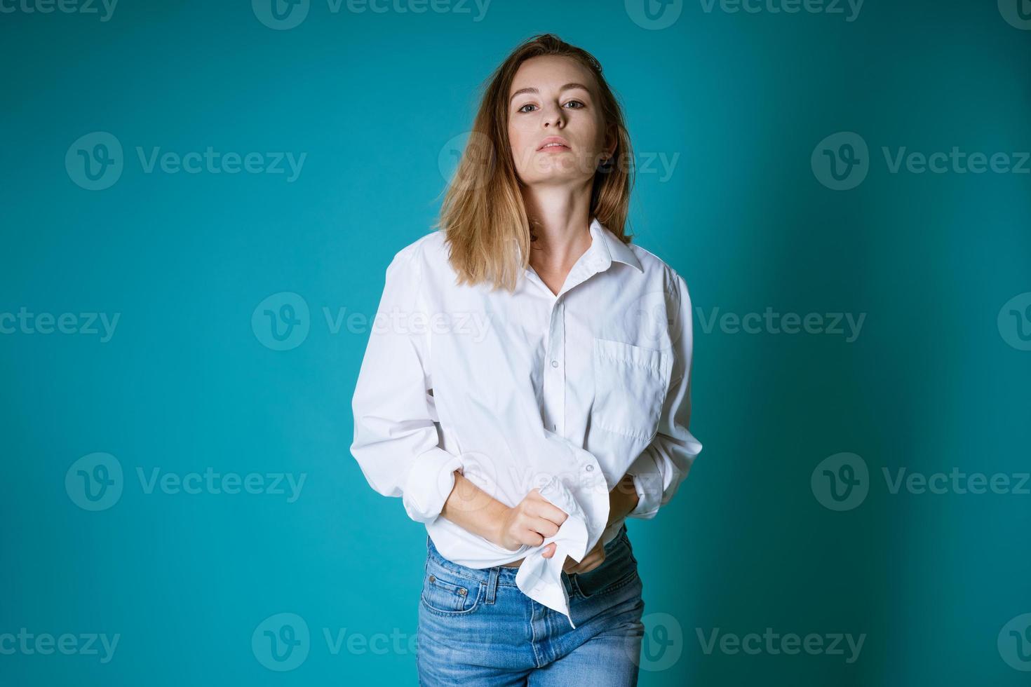 Close-up de joven mujer vistiendo la camisa azul y pantalones negros  ajustados de pie sobre fondo blanco Fotografía de stock - Alamy