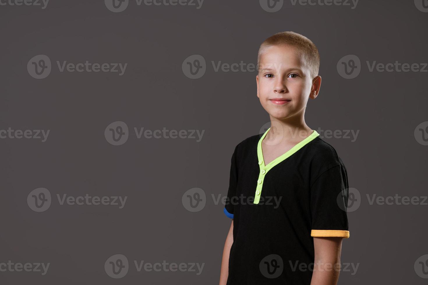 Portrait of  young guy in  black T-shirt on  gray background photo