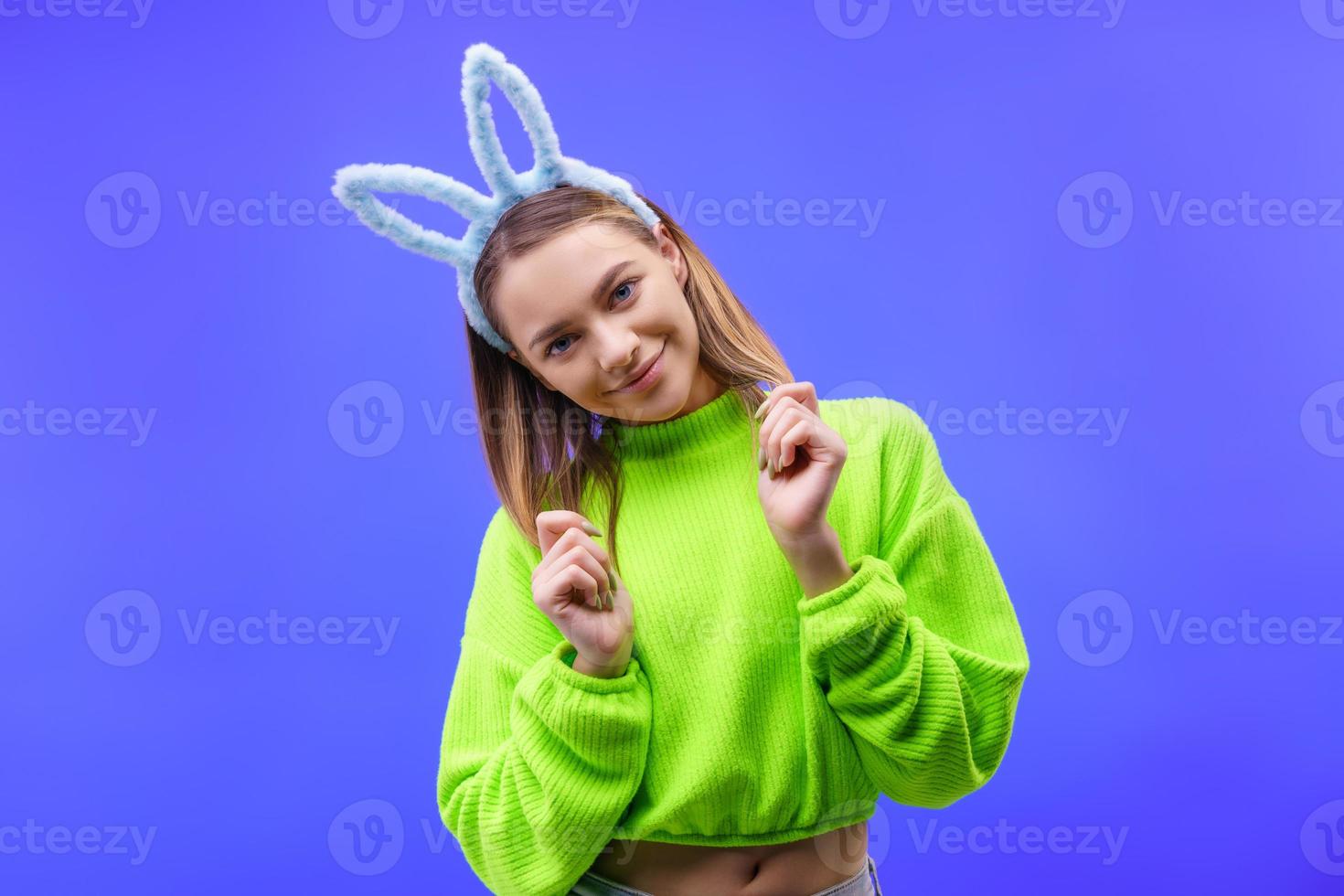 young woman in bunny ears on a blue background photo