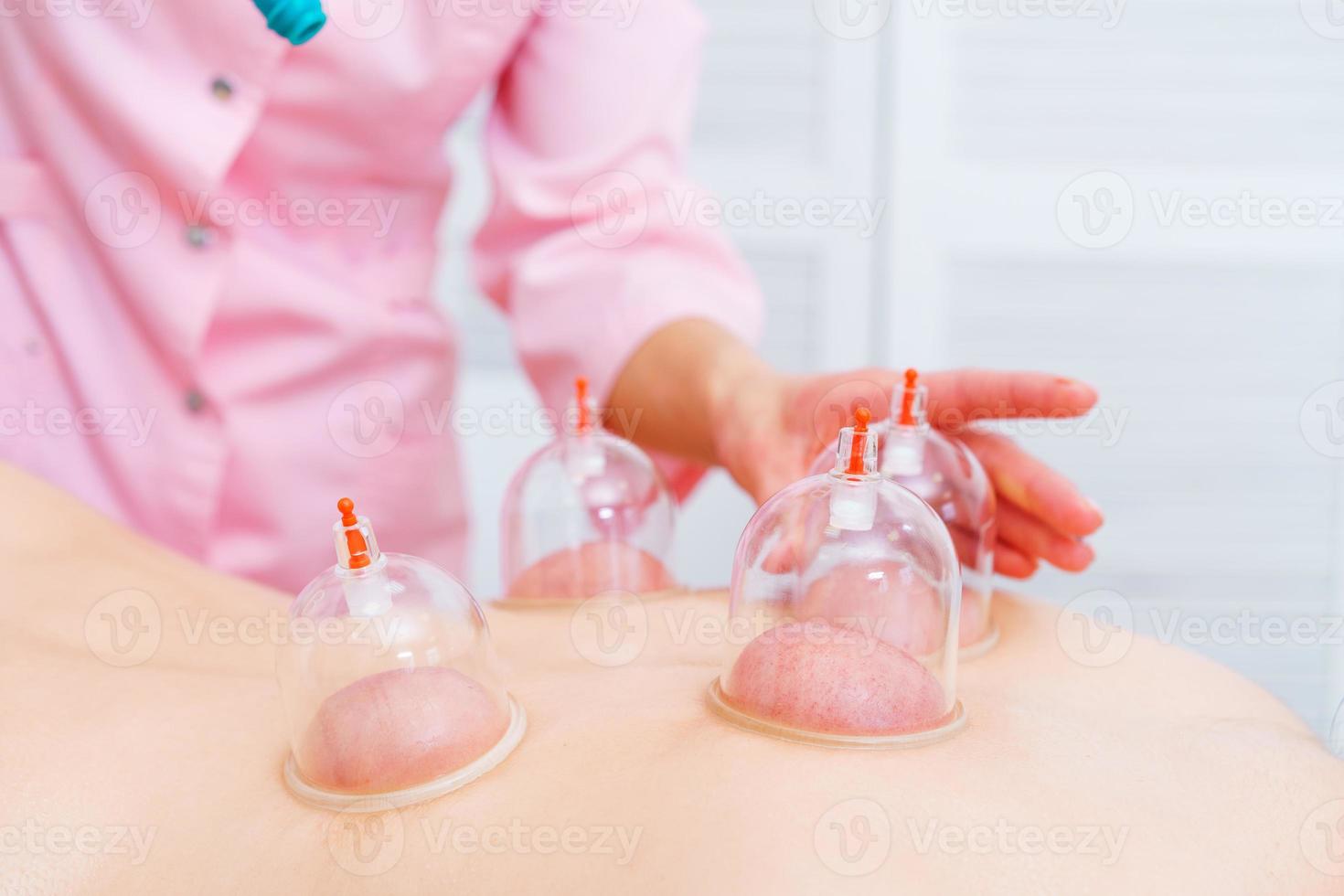 Relaxed young woman receiving canning on her back at spa. Vacuum massage. Woman photo