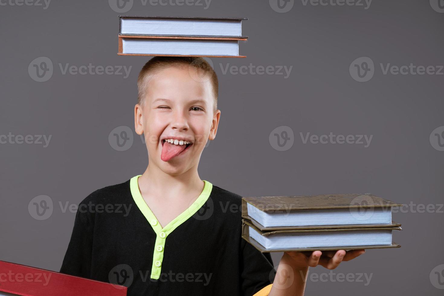 funny boy holding a book in his hands and on his head photo