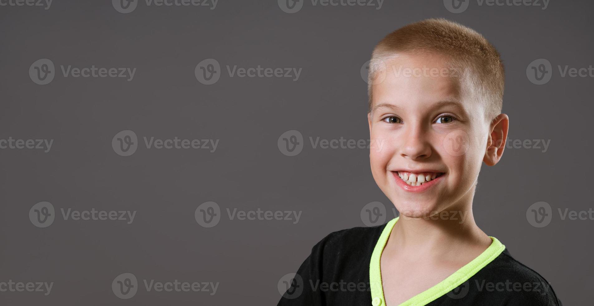 Portrait of  young guy in  black T-shirt on  gray background photo