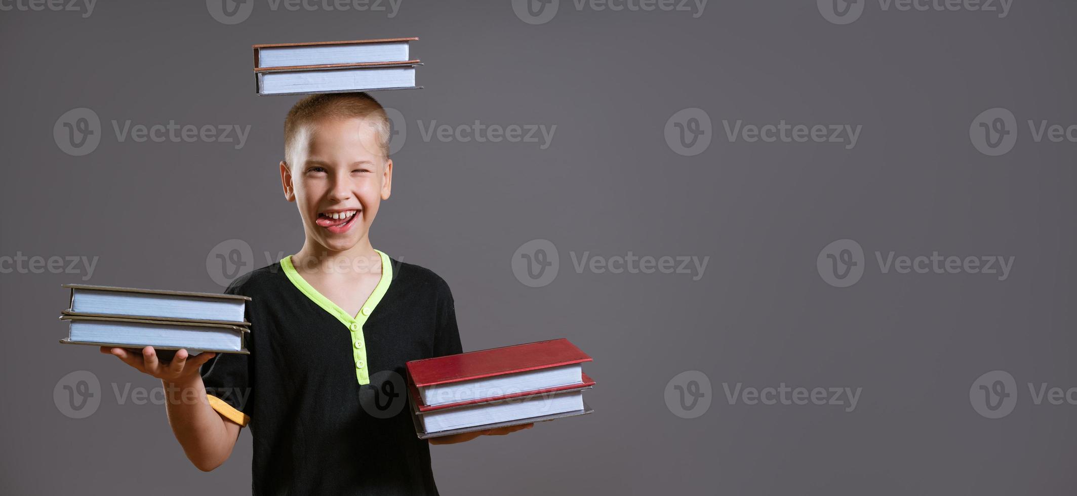 chico gracioso sosteniendo un libro en sus manos y en su cabeza foto