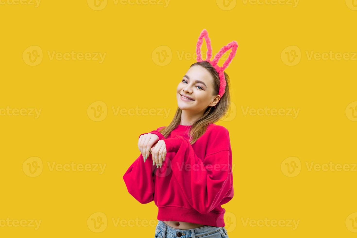 young woman in bunny ears on a yellow background photo