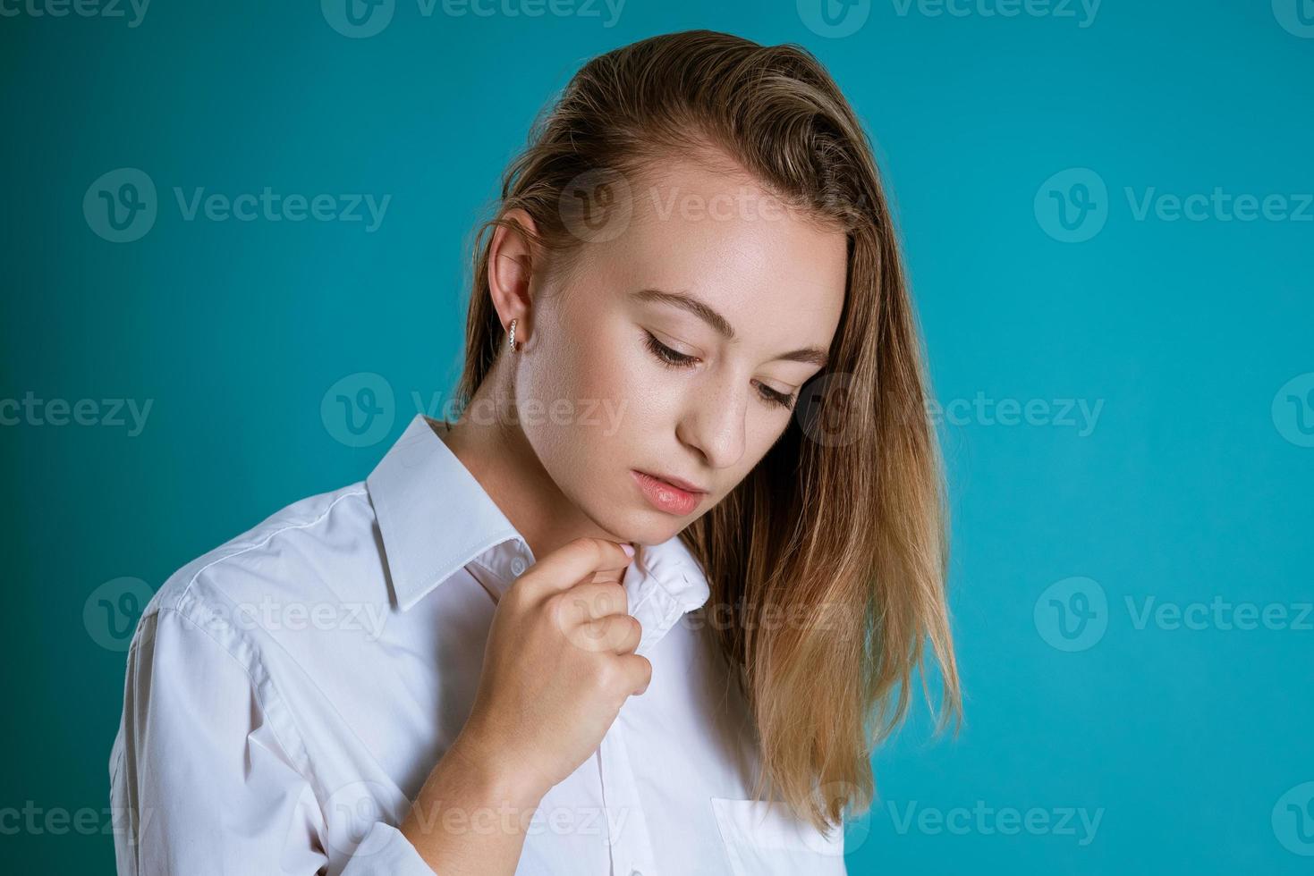 retrato de mujer joven con cara triste sobre fondo azul foto