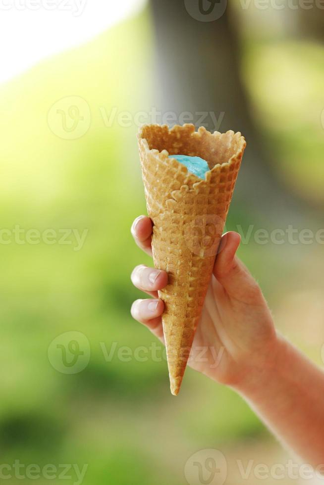 ice cream horn in a woman's hand. Delicious ice cream melts and flows to the horn in the woman's hand photo