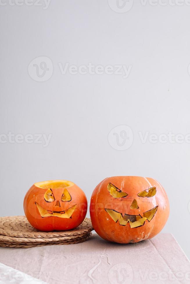 Halloween pumpkins smile and scary eyes for party night. Close up view of scary Halloween pumpkins with eyes on the table at home. Selective focus photo