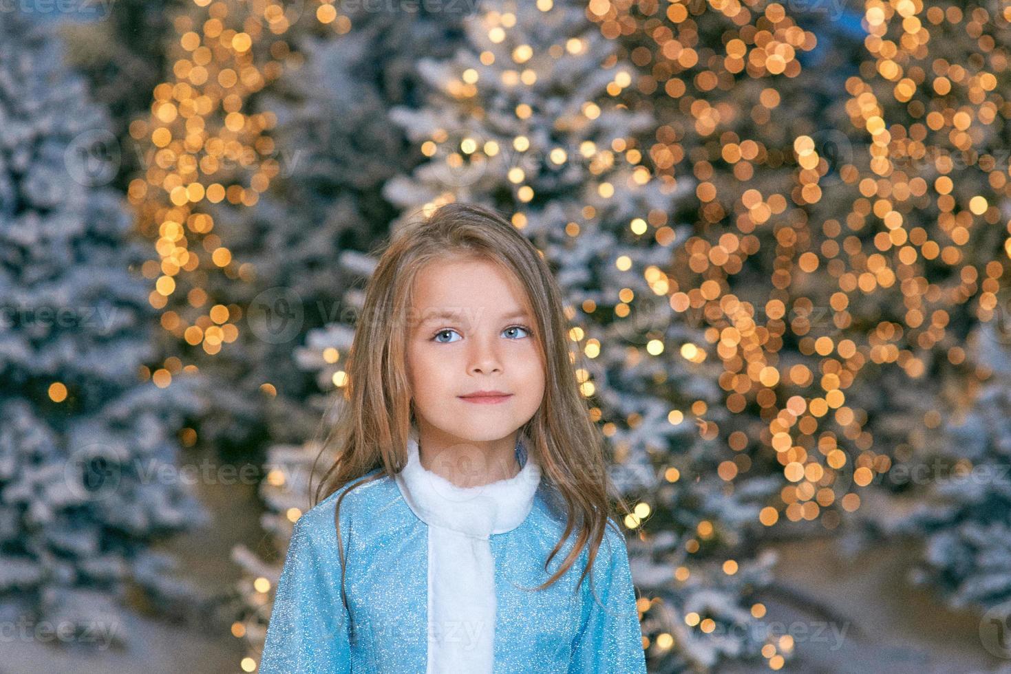 cute Caucasian blonde girl walking winter christmas forest with lights. New year, fairy tale concept photo