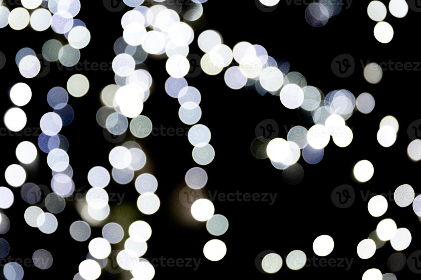 Abstract glitter sparkle bokeh defocused on black background. many round light on background photo