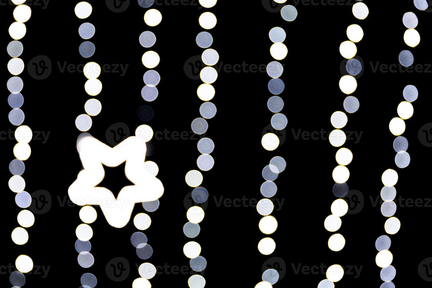 Abstract bokeh of white city lights on black background. defocused and blurred with star of light photo