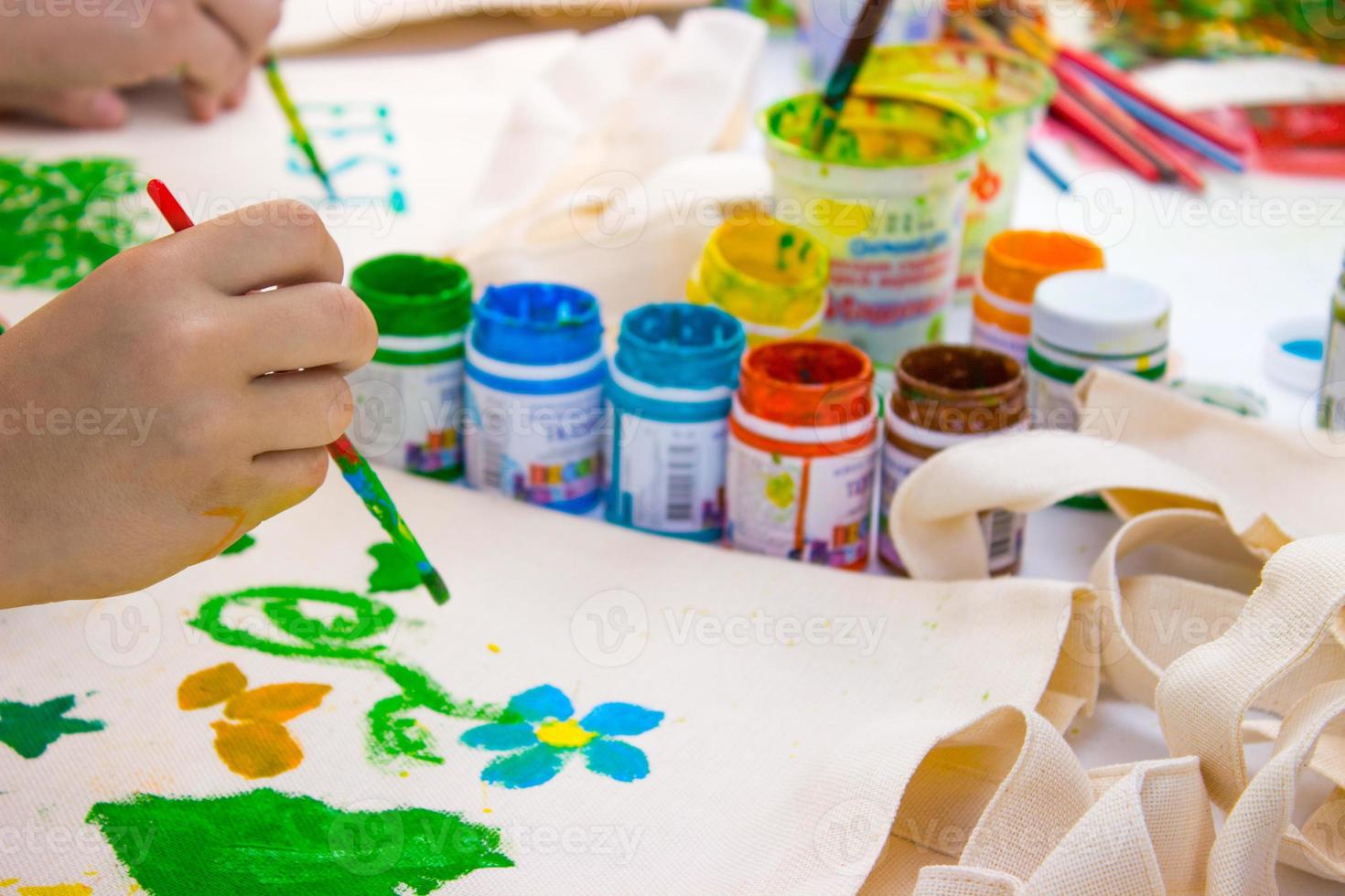 Brush in the children's hand that draws a water colors photo