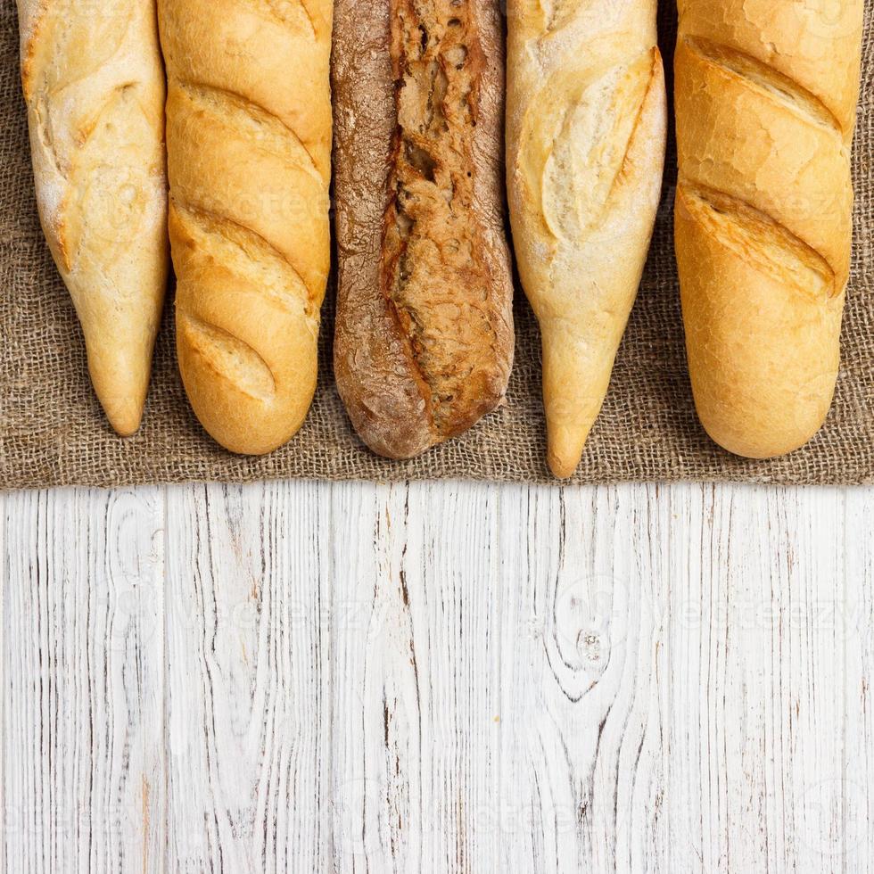 Assortment of fresh French baguettes on a wooden table photo