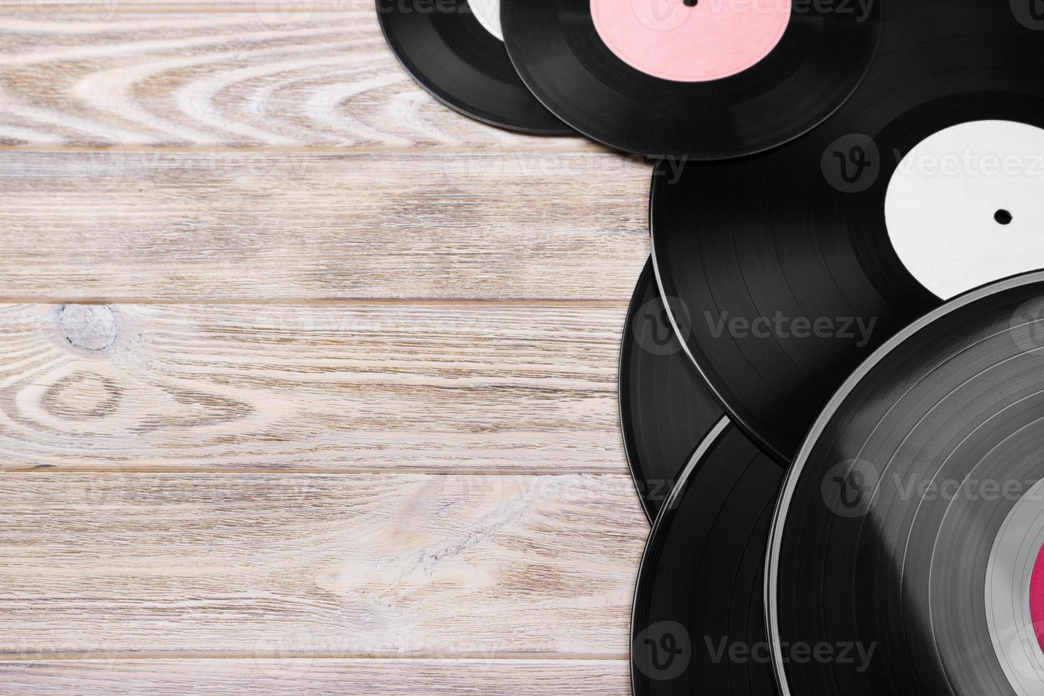 Retro vinyl records on the bright wooden background, selective focus. Top view. Copy space photo