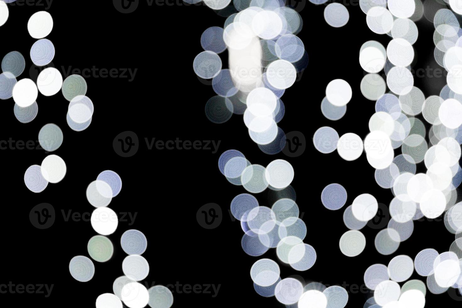 Unfocused abstract white bokeh on black background. defocused and blurred many round light photo