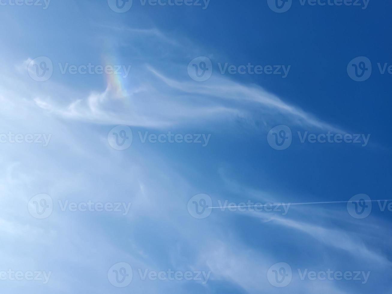 Estelas de condensación de aviones en el cielo azul entre algunas nubes foto