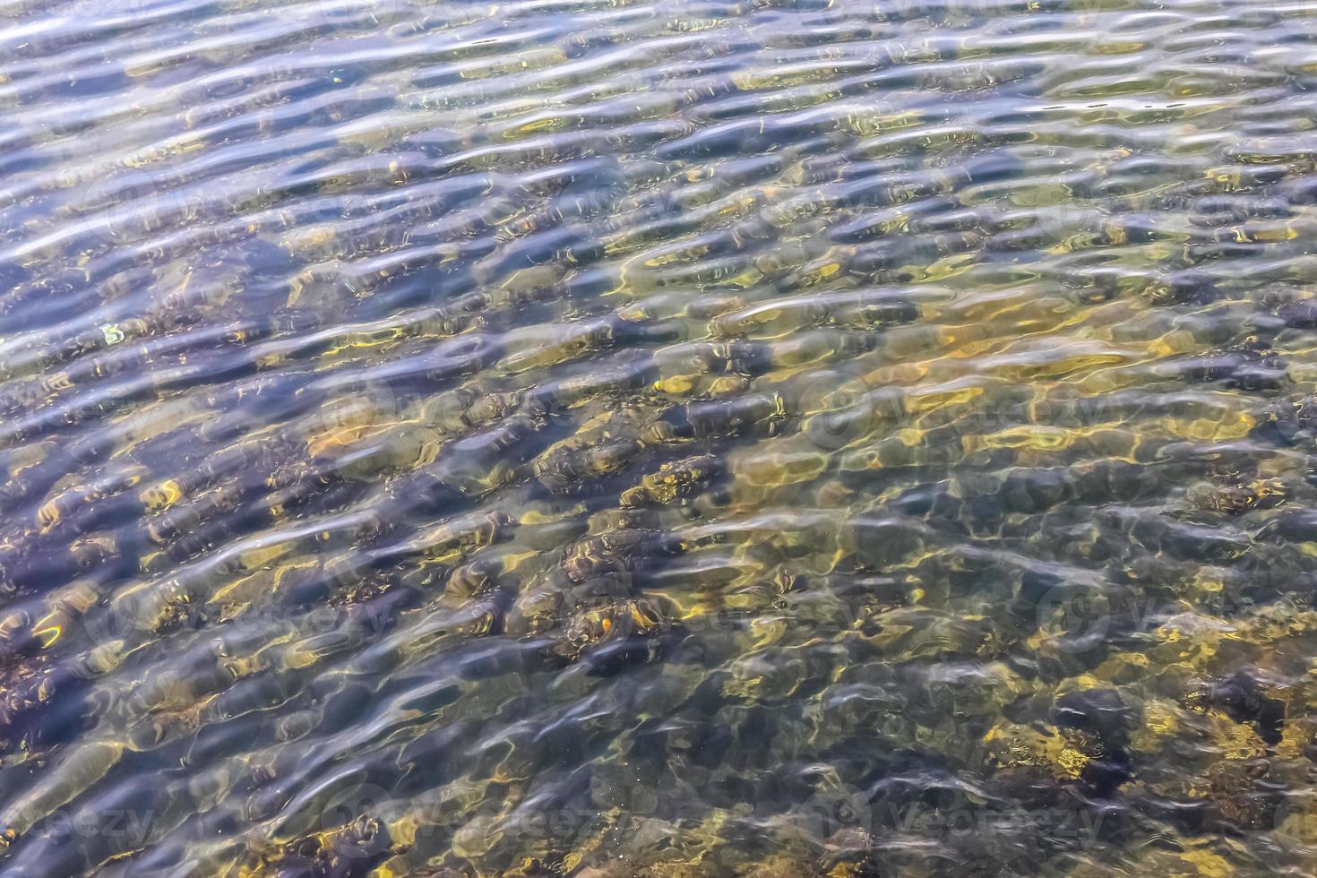 Water surface with waves and ripples and the sunlight reflecting photo