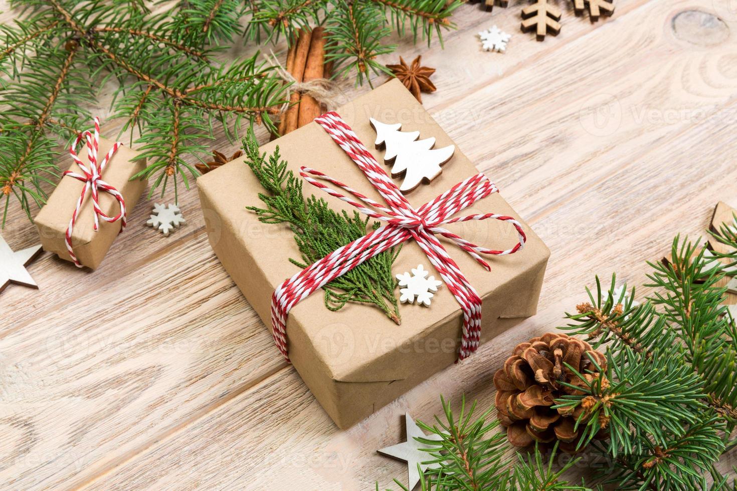 Christmas background with fir tree and gift box on wooden table. Top view with copy space for your design photo
