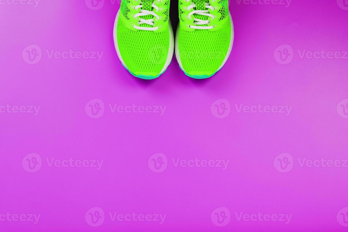 Green running shoes on a purple background. photo