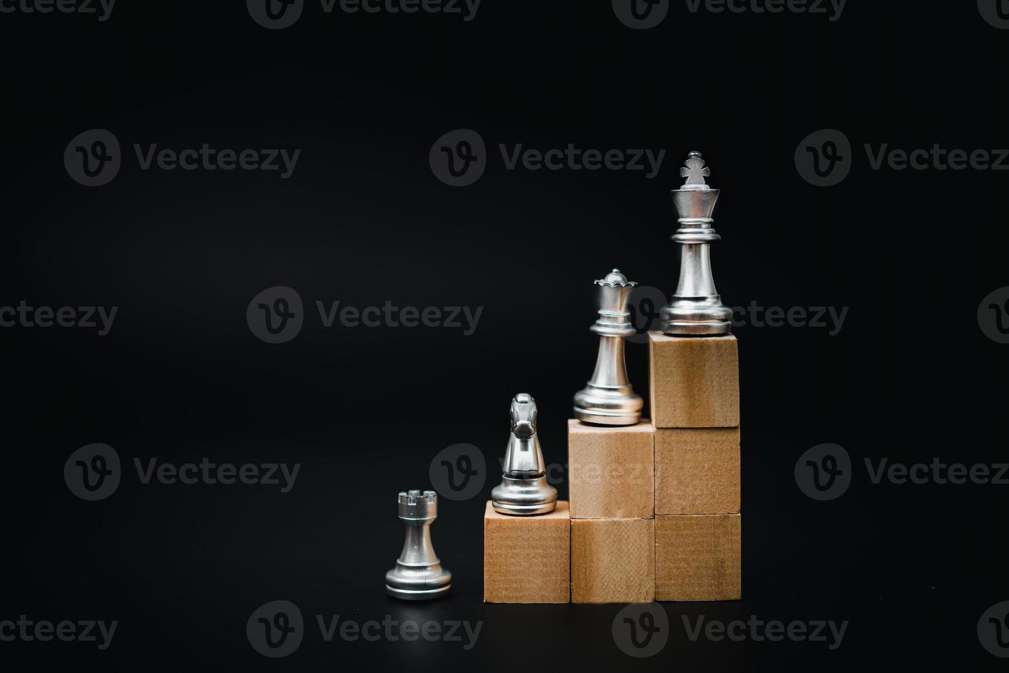 wooden cube and chess, business and marketing strategy concept in planning goals on black background. photo