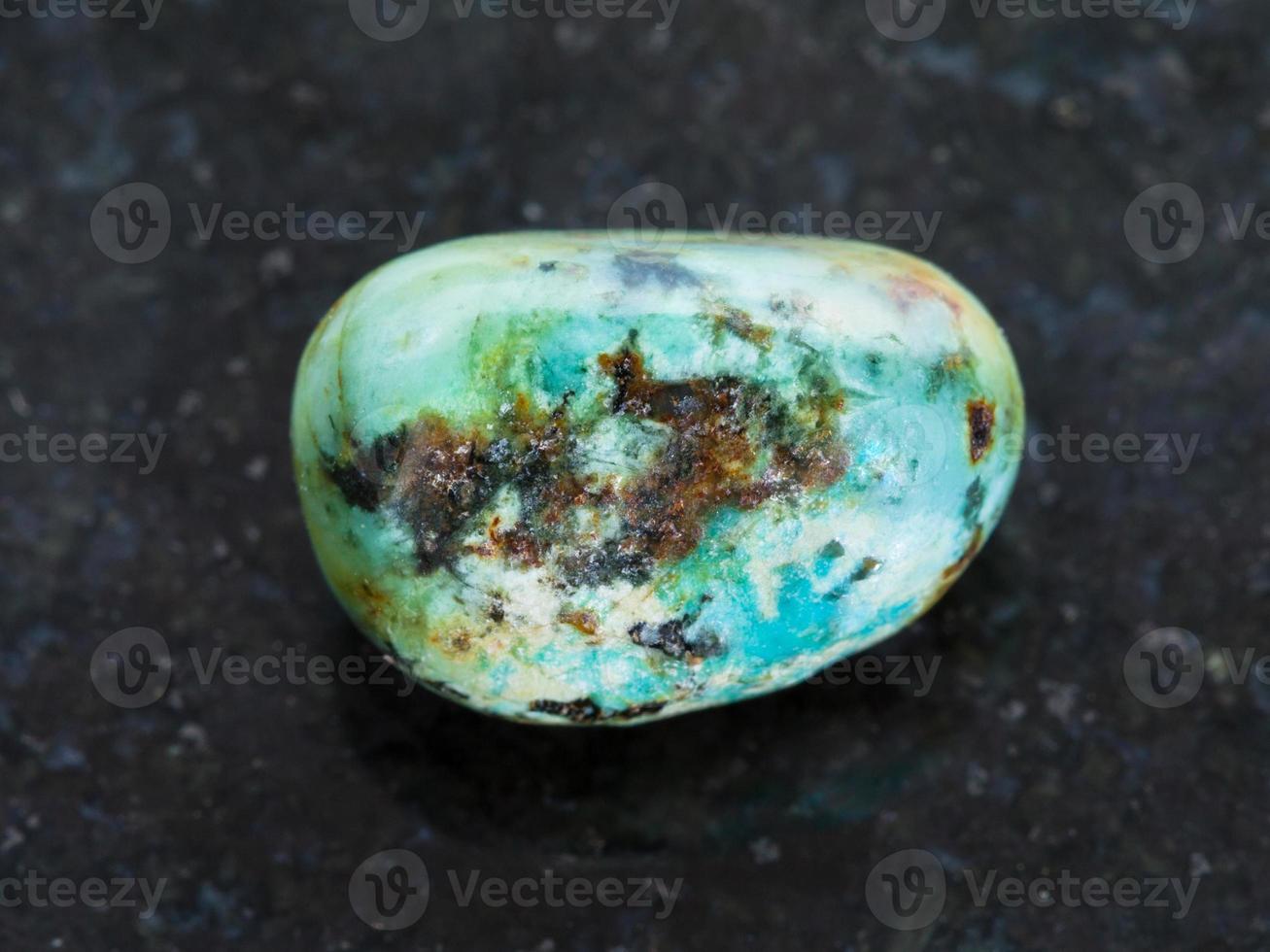 polished turquoise gemstone on dark background photo