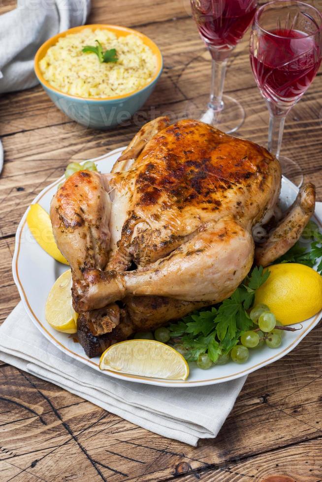 Baked chicken, mashed potatoes and wine glasses for dinner on the festive table. photo