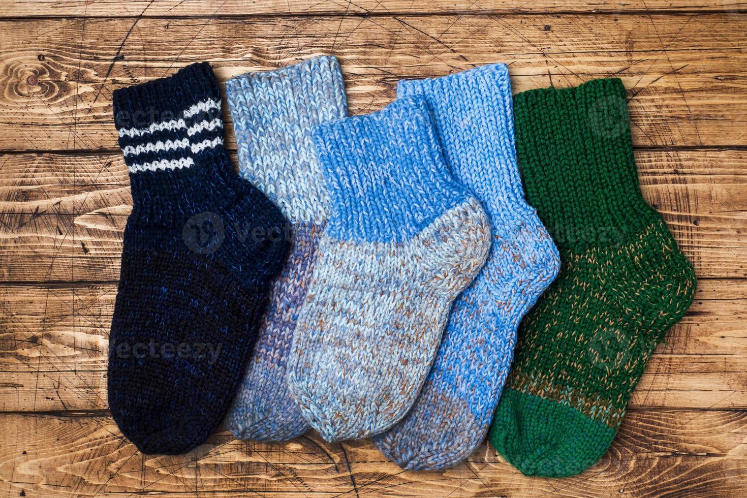 Warm wool knitted socks for cold winter on wooden background. photo