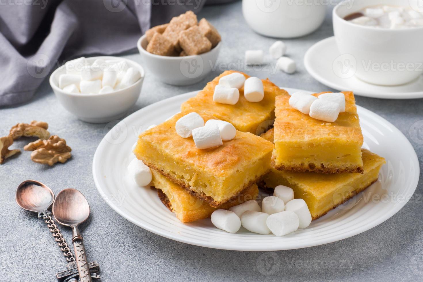 Pieces of delicious pumpkin pie with marshmallow and nuts on a plate. photo