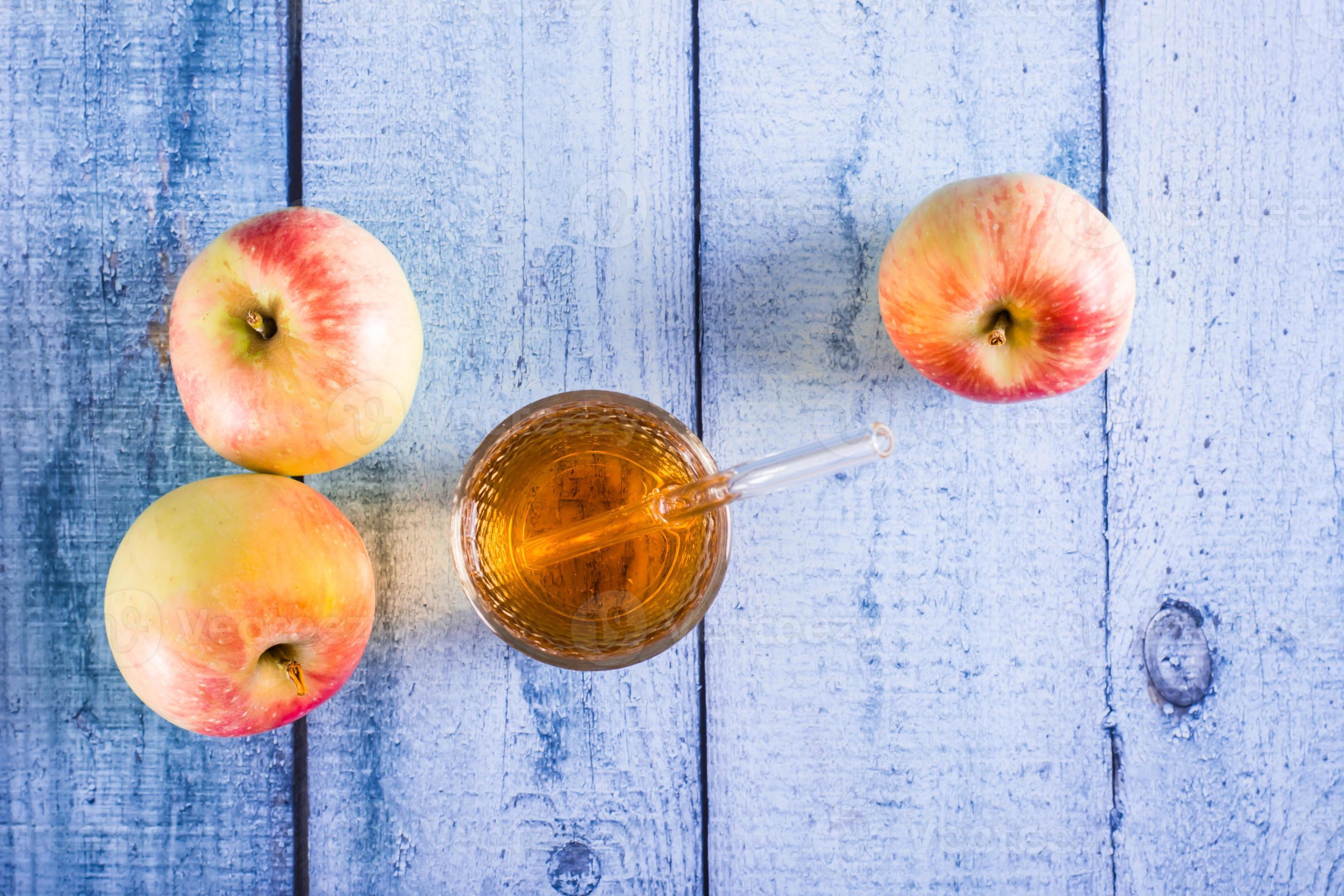 Fresh apple juice in a glass and fruits on the table. Homemade drinks