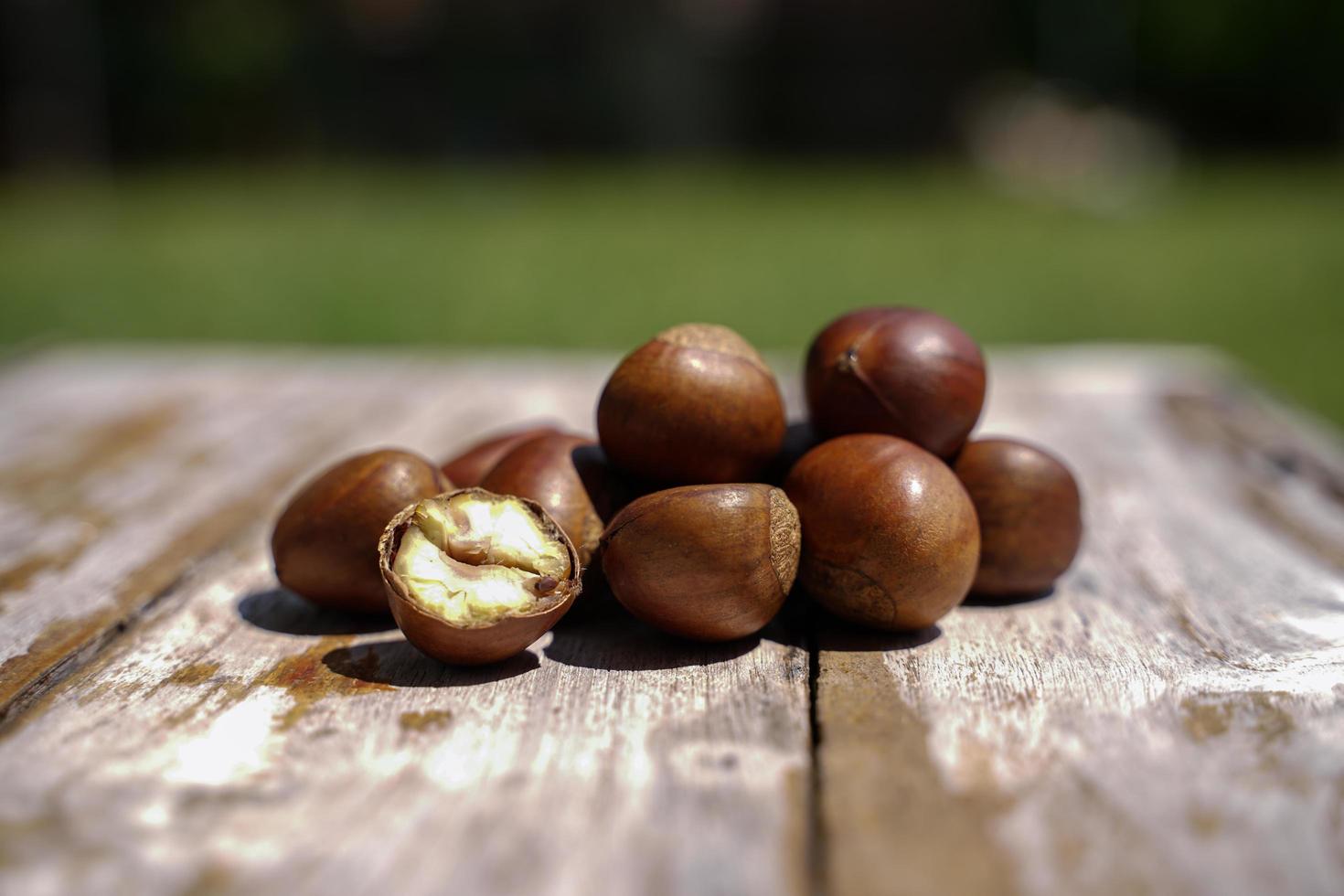 castañas frescas aisladas en un suelo de madera, las castañas tienen un sabor dulce aceitoso. foto