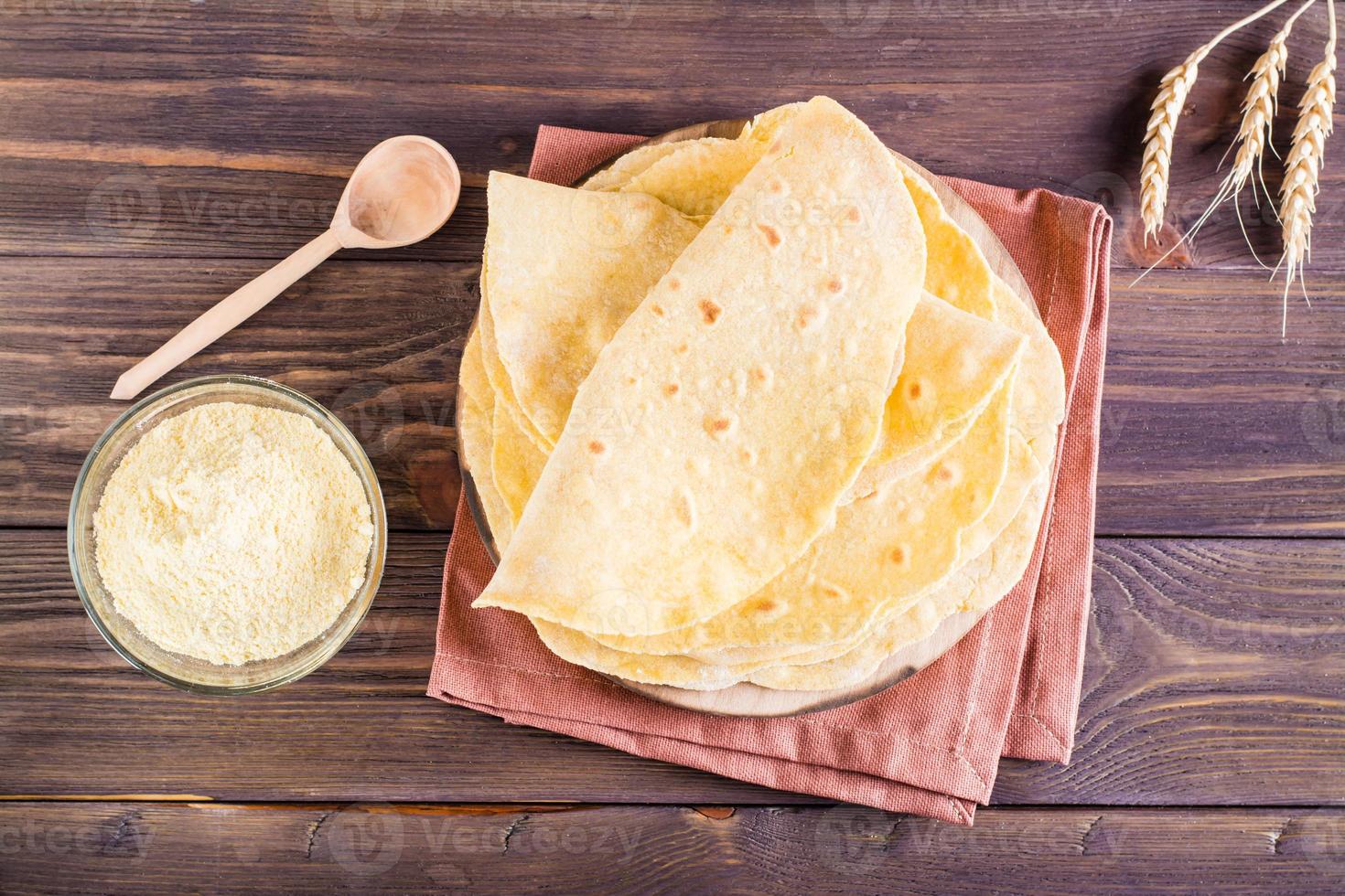 A stack of baked mexican tortillas on a board on the table. Homemade pastries. Top view photo
