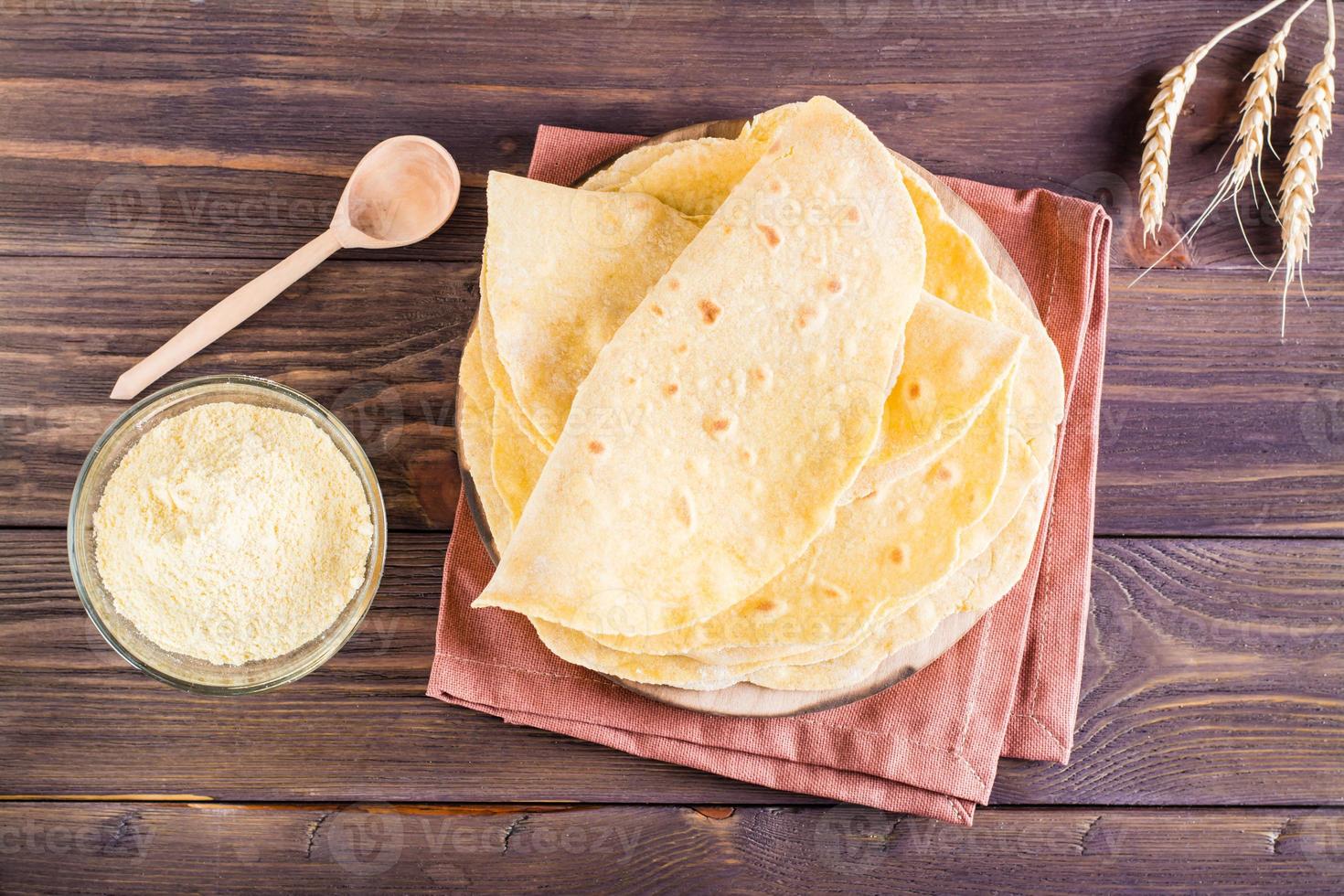 una pila de tortillas mexicanas horneadas en un tablero sobre la mesa. pasteles caseros. vista superior foto