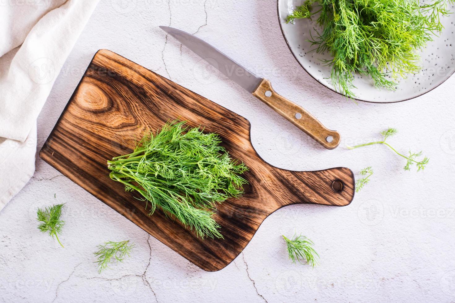 A bunch of fresh dill on a cutting board on the table. Organic seasoning. Top view photo