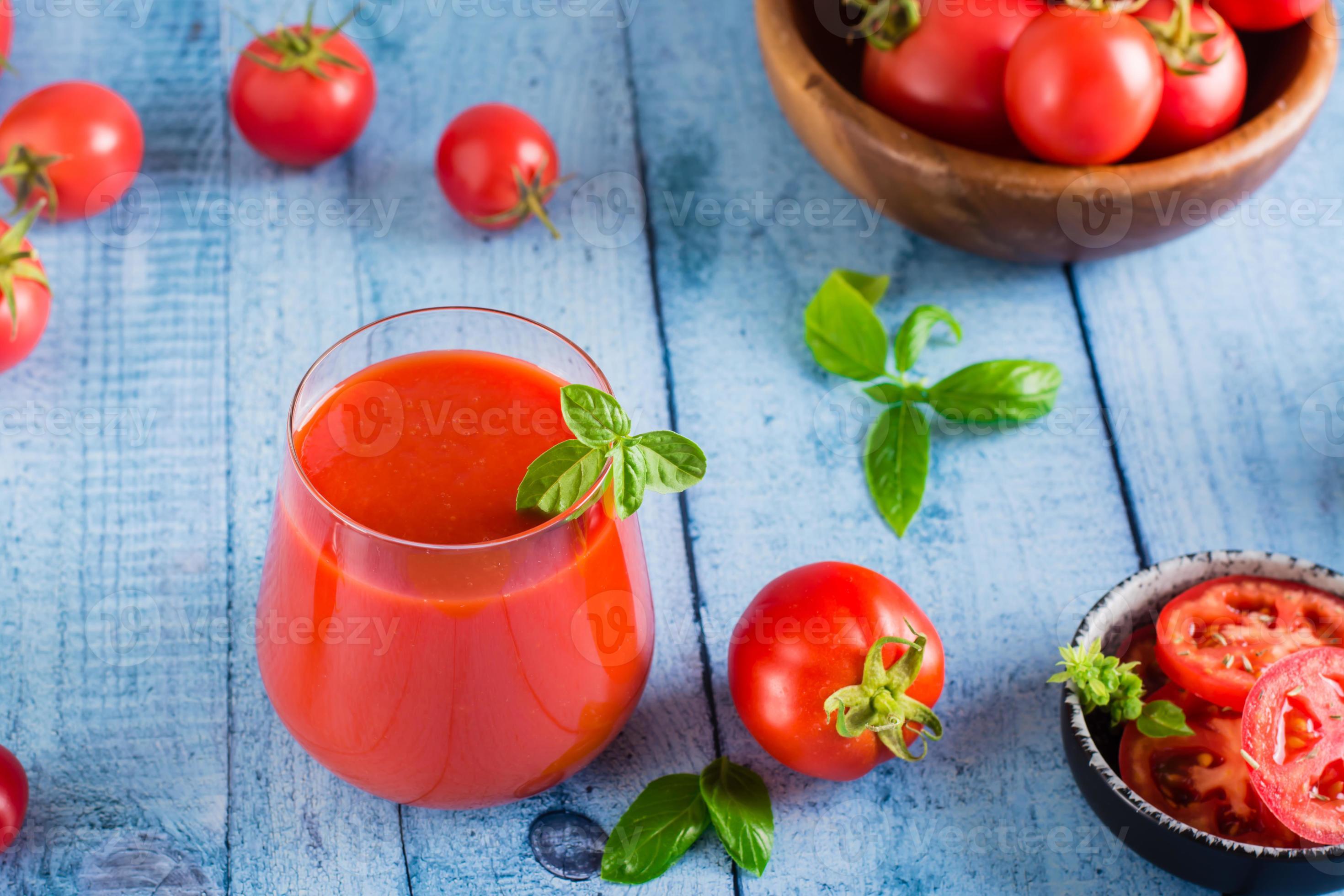 Tomato juice with basil in glasses and vegetables on the table. Organic