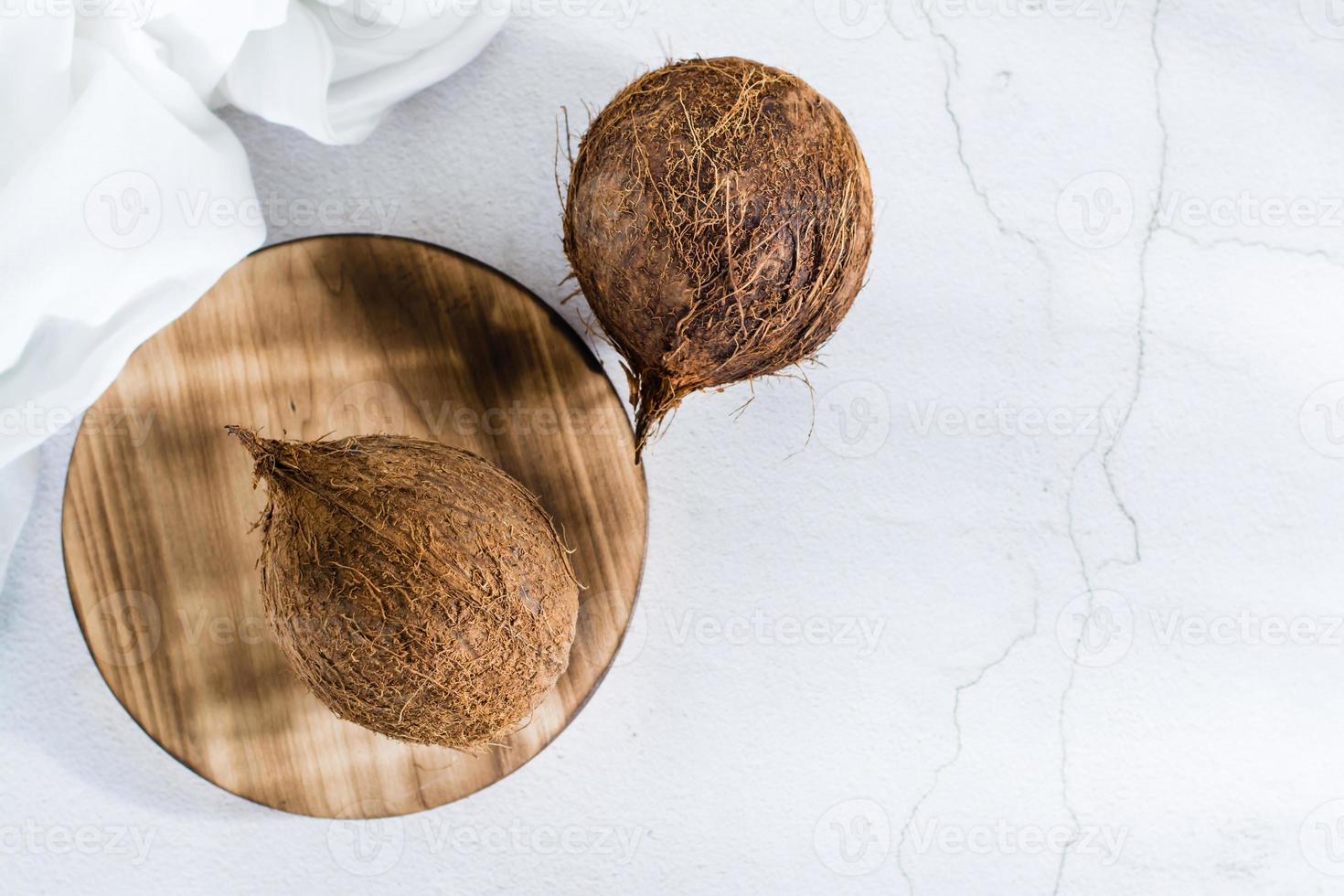 Two whole ripe coconuts on the table. Tropical fruits. Top view photo