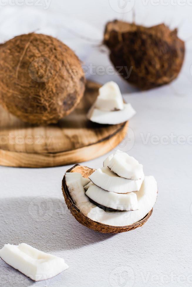 Pieces of ripe coconut on the table. Tropical fruits. Natural source of antioxidants. Vertical view photo