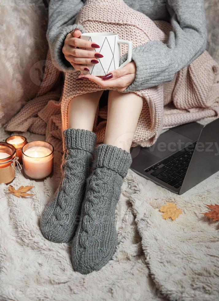 Cozy home, woman covered with warm blanket, drinks coffee. photo