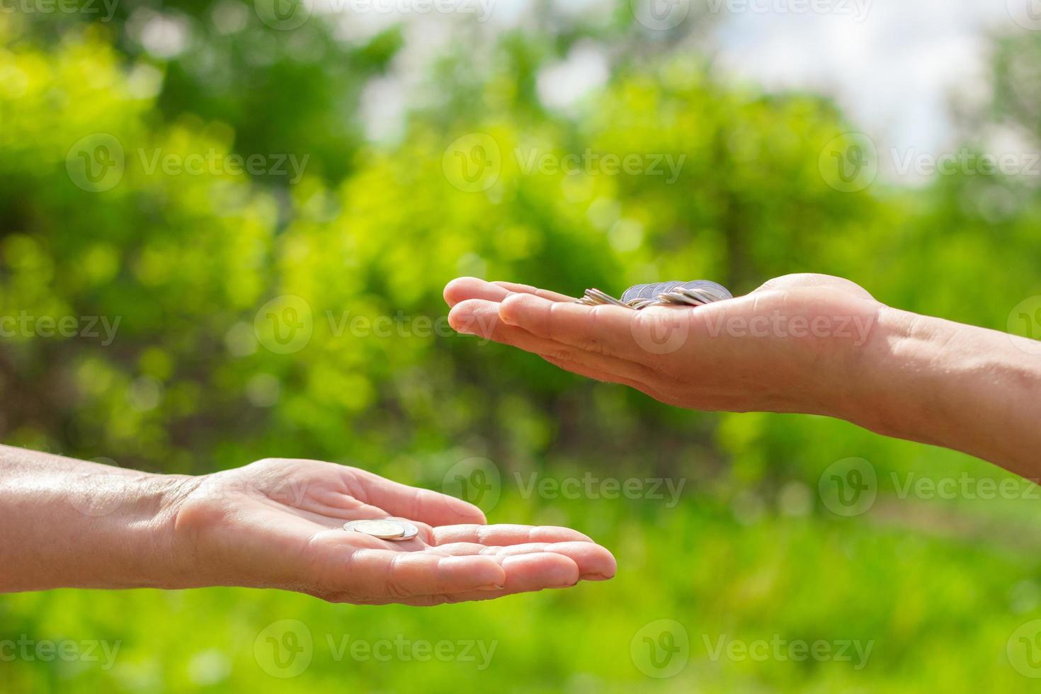 hand in hand gives coins on green background, Finance concept and loans. photo
