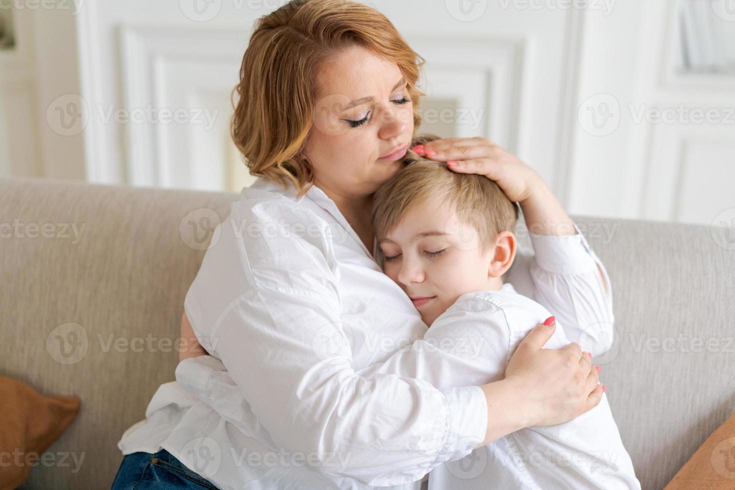 Happy young caucasian mother hugs cute little preschool son together at home photo